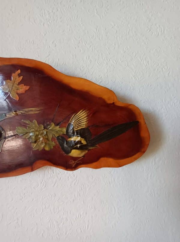 A Magpie Wooden Wall Plaque with birds and leaves on it.