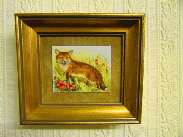 A framed Rita.E.Whittaker miniature painting of a fox on a wall.